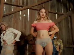 Beautiful girl with long hair undressing on the bed and caresses pee